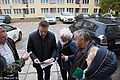 Prezydent Olsztyna Piotr Grzymowicz i mieszkańcy bloku przy ul. Kętrzyńskiego oglądają zdjęcia sprzed inwestycji i po jej zakończeniu
